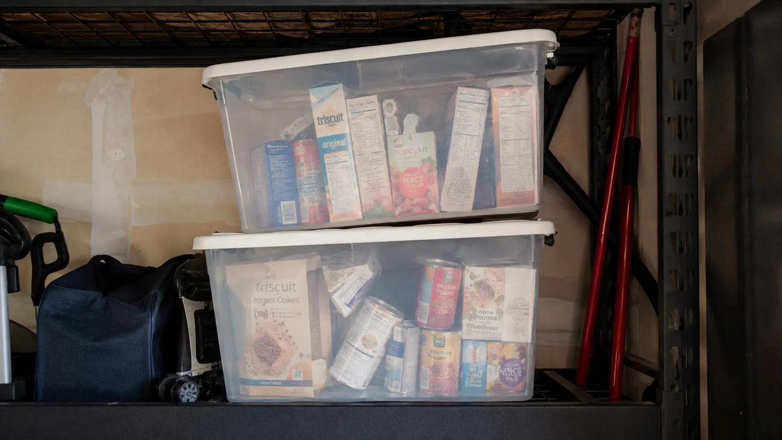 Two clear pantry bins stacked on a shelf with the top bin sitting slightly off center